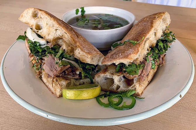 Pho beef dip sandwich with fresh herbs and shitake jus