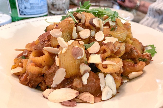 Braised lamb sugo with lemon zest over saffron shell pasta