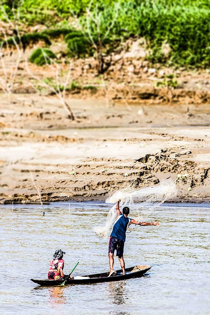 Wherever we were going, we cruised past men in dugout canoes casting nets near the river’s edge.