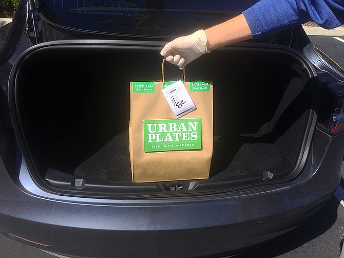 An Urban Plates meal, dropped into a car trunk, curbside, for no contact pick-up