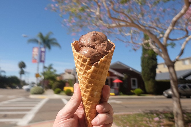 A scoop of malted chocolate brownie ice cream in a house waffle cone at Mr. Trustee