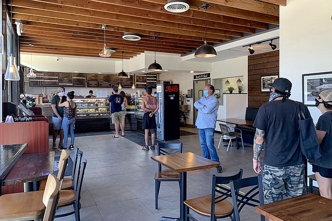 Bagel and donut fans line up six feet apart at Solomon Bagel Company.