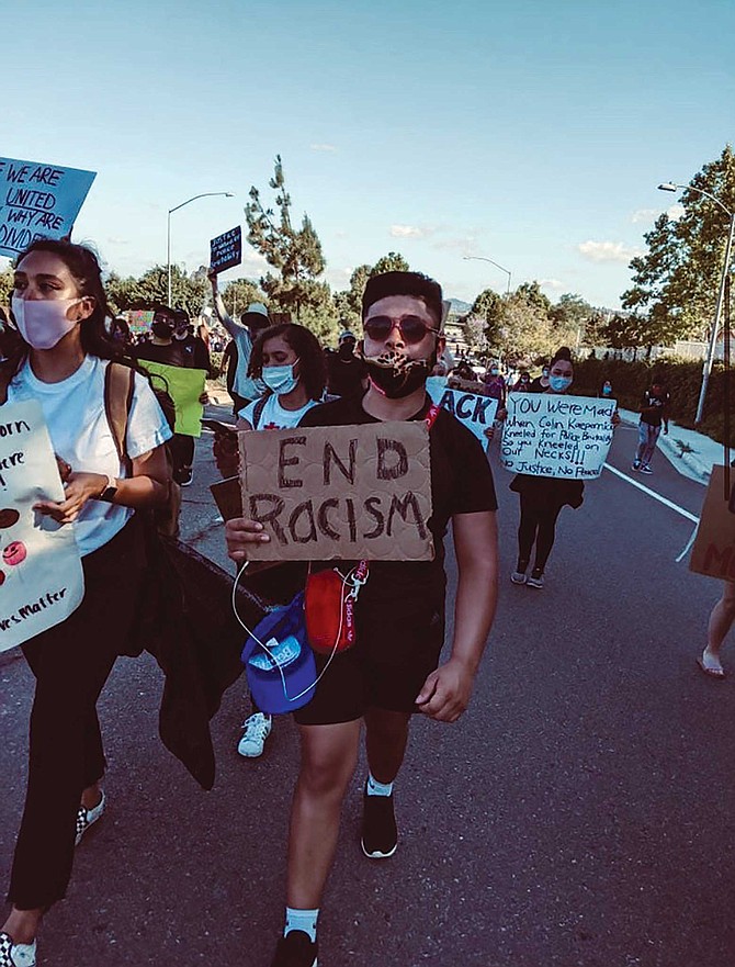 Arturo Gonzalez holds an “End Racism” sign at a San Diego BLM protest.