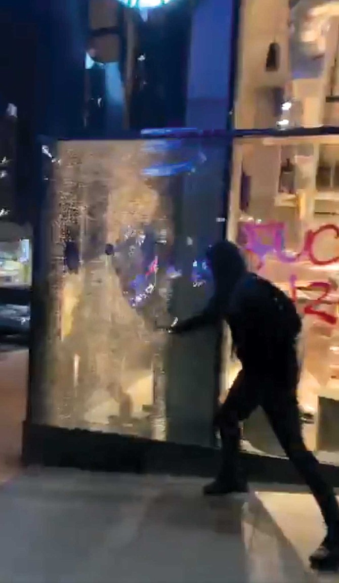 At about the 40-minute mark of Gonzalez’s three hour-plus live clip, he approaches the Starbucks on the corner of Ash Street as a person wearing a black ski mask smashes the coffee shop’s freshly tagged windows.