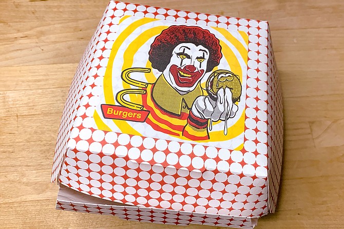 The C&C fast food burger box, with creepy clown and fast foodie logo