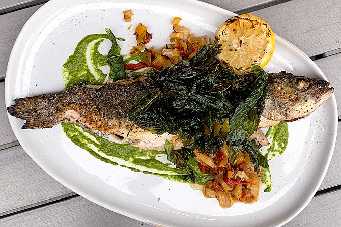 Hearth grilled branzino topped with fried herbs