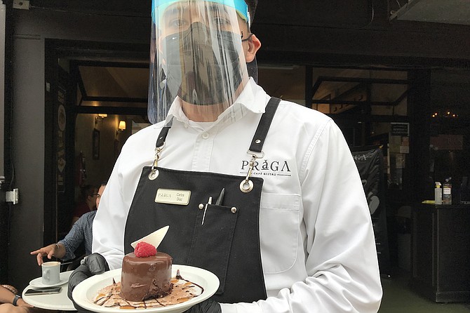 Carlos, rigged up like a covid warrior, brings a chocolate mousse dessert.