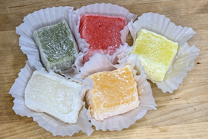 A selection of mochi, glutinous rice cakes (clockwise from left): green tea, strawberry, pineapple, orange, coconut