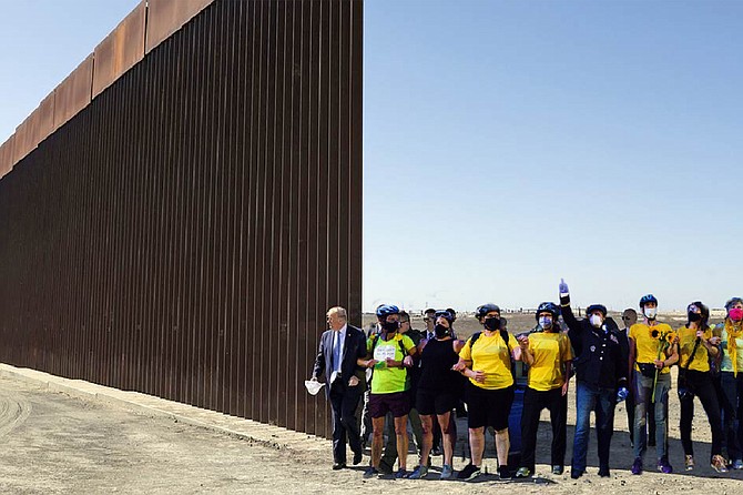 Wallflowers: a Wall of Moms contingent links arms with President Trump beside a section of the as-yet-unfinished border wall. “What Trump is doing in Portland is indefensible,” says Wokenshield. “But we here at Wall of Moms aren’t out to play politics. We’re out to protect the children. So of course we’ll stand with him against the rising tide of drugs washing over our southern border. And we won’t desecrate any Kumeyaay land while we’re doing it.”