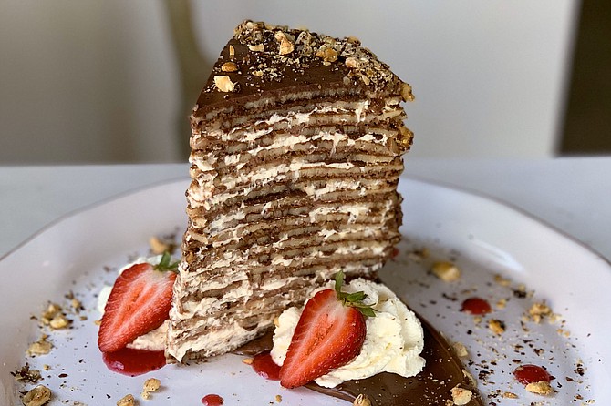 A cake of 23 crepes with chocolate hazelnut spread, chocolate whipped cream, and hazelnuts