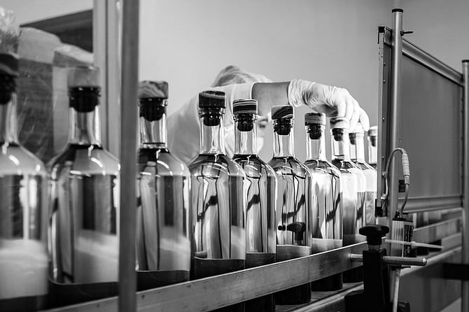 A distillery worker inspects bottles of Izo Mezcal, a San Diego brand that offers made in Mexico agave spirits.