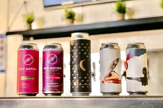 Cans of New Motion hard seltzer and hard tea, alongside cans of Embolden Beer Co. Both now brewed in Miramar.