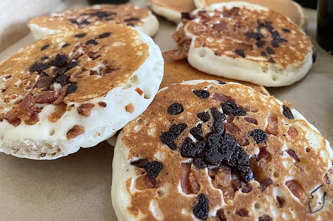 A pizza box filled with chocolate bacon silver dollar pancakes