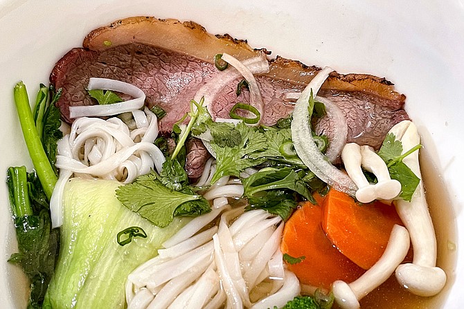 Smoked and seared wagyu picanha served over phở, with added vegetables (half a take-out serving shown here, prior to adding the usual garnishes)