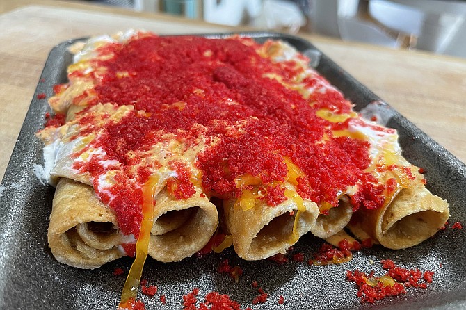 Flamin' Hot Rollies: beef rolled tacos topped by melted cheese, sour cream, and loads of crush Flamin' Hot Cheetos dust
