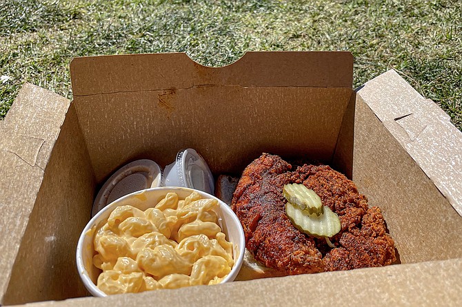 An extreme chicken tender with a side of macaroni, in a box ready to picnic