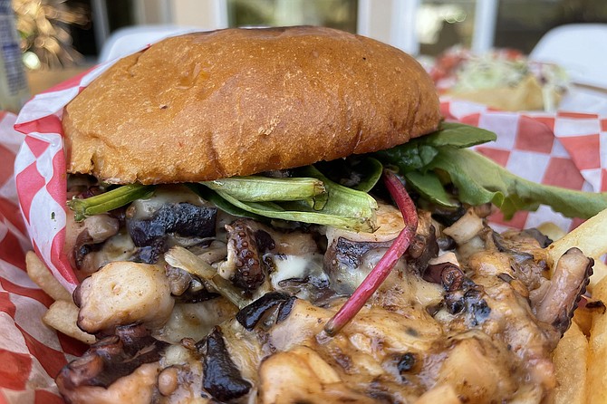 A messy pile of octopus and melted cheese pours forth from the Ay-Ay Burger.