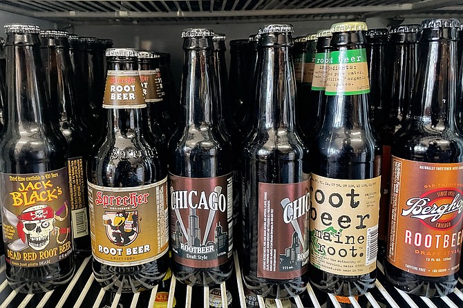 A single shelf of root beer brands in a cooler filled with dozens of them