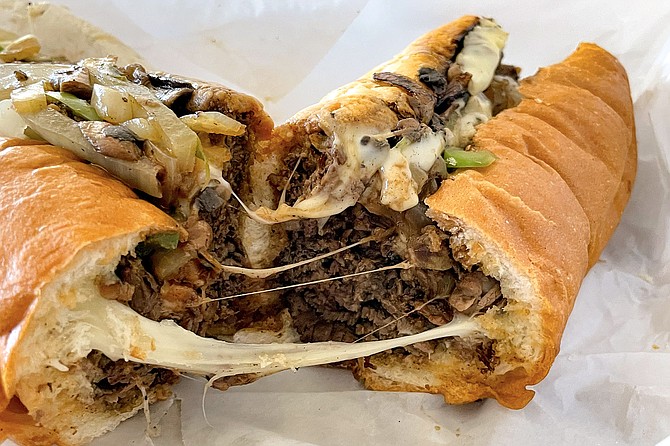Melted provolone bridges the gap between halves of this smoked ribeye cheesesteak.