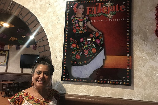 Survivor - Owner Lucy Contreras, and poster showing her in traditional Oaxacan dress.