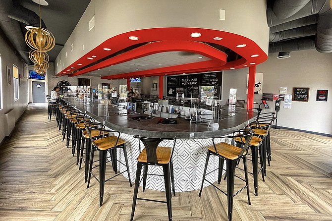 A long bar, where each seat has its own rangetop