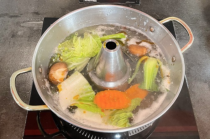 Vegetables and meat cook quickly within bubbling dashi broth.