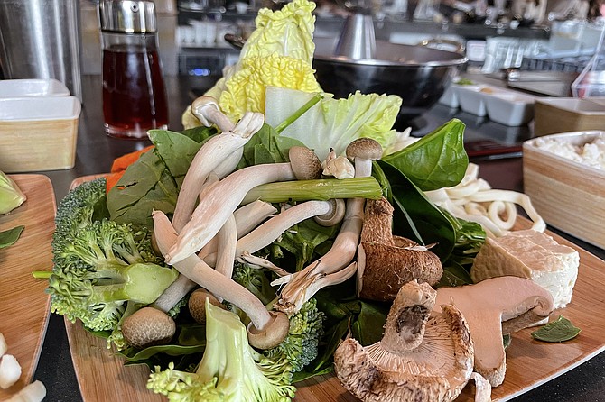 Vegetables and meat cook quickly within bubbling dashi broth.