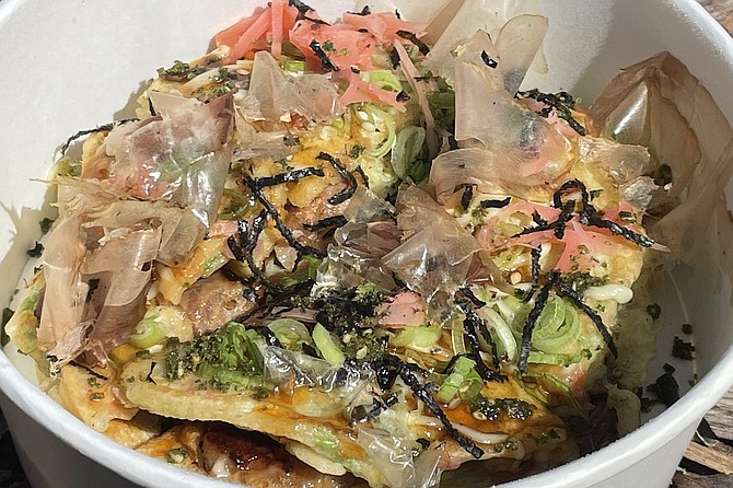 Okonomiyaki, a Japanese savory pancake made with eggs, cabbage, and in this case chashu pork