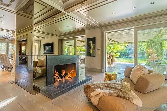 A two-sided fireplace that’s outfitted from floor to ceiling with mirrors on every side.