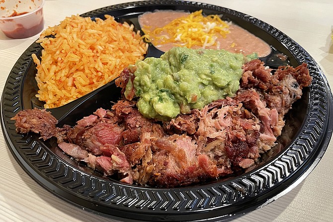 Carnitas combo, with guacamole, red rice, refried beans, and corn tortillas