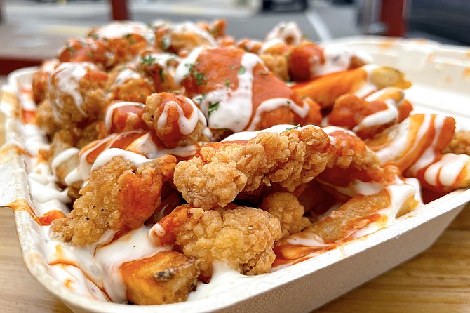Fried chicken nuggets slathered in ranch and buffalo sauces, served over fries