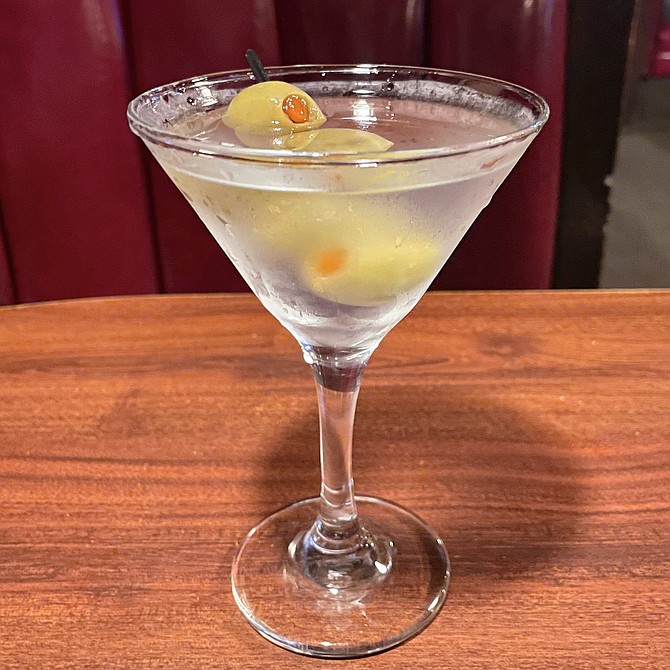A martini served in a plush, red vinyl booth