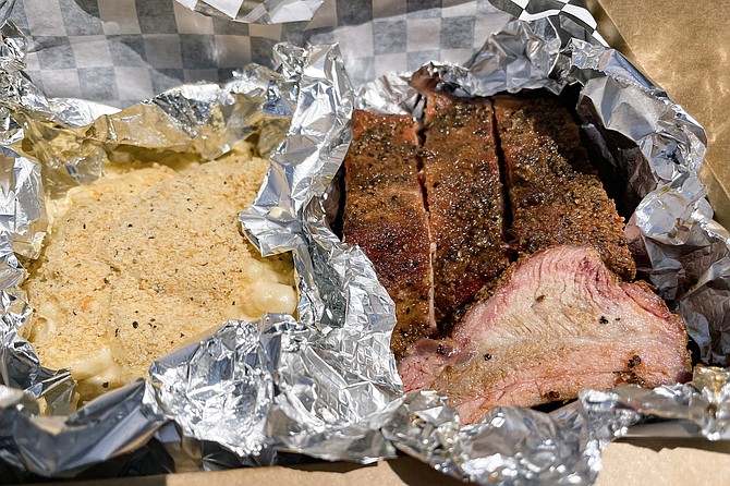 A meat box featuring dry rub baby back ribs, mac & cheese, and coleslaw