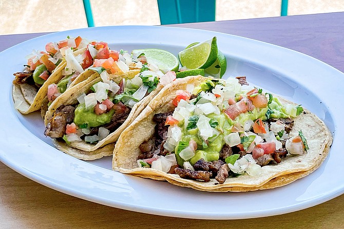A regular, carne asada taco (front) with three carnitas mini tacos