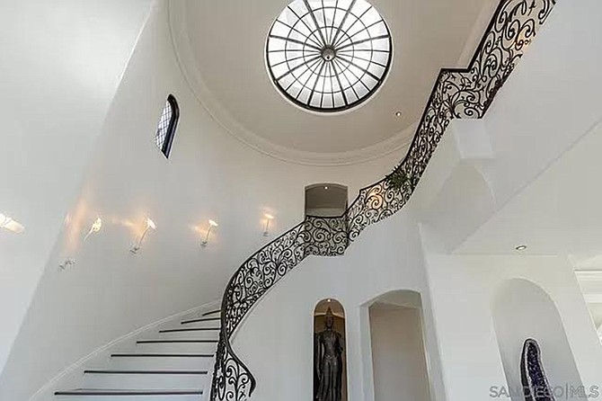 Black balusters adorn the white flight of stairs.