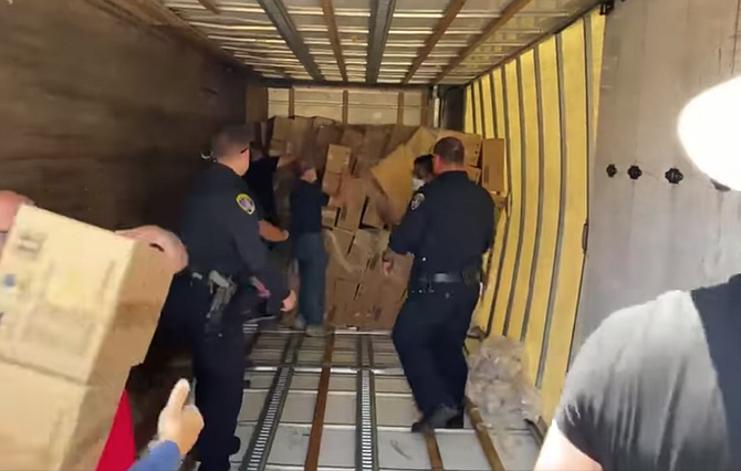 Two police officers and four individuals in civilian clothing formed a daisy chain from turned-over truck in Mira Mesa.