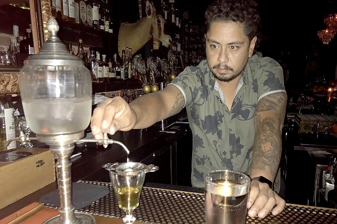 Sober shot of Ivan adjusting drip from ancient iced water fountain.