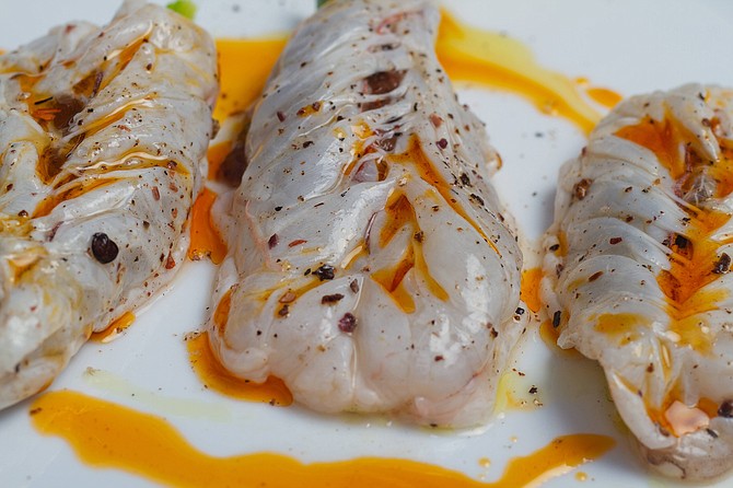 Andrea kept rearranging the third course, the crudo camarón enchilado. Three big shrimp with asparagus underneath covered in a spicy oily sauce and spices.