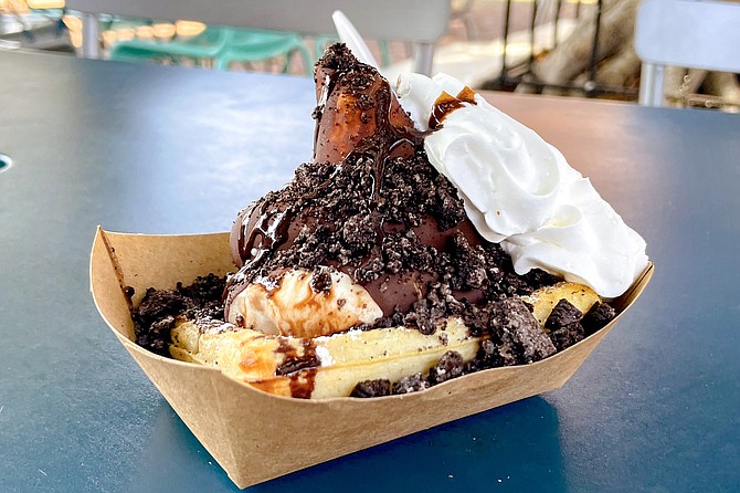 Chocolate-dipped soft serve ice cream atop a Belgian waffle with chocolate syrup and Oreo crumbles