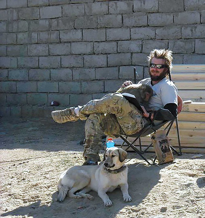Josh, Satchel, and Luci(fer) the monkey enjoy an afternoon reading at VSO (Village Stability Operations) Harrison base.