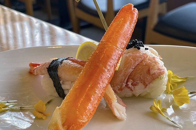 A snow crab sushi order garnished with a crab leg