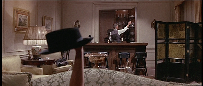 Monica (Elizabeth Ashley) appears before Jonas (George Peppard) with hat in hand.