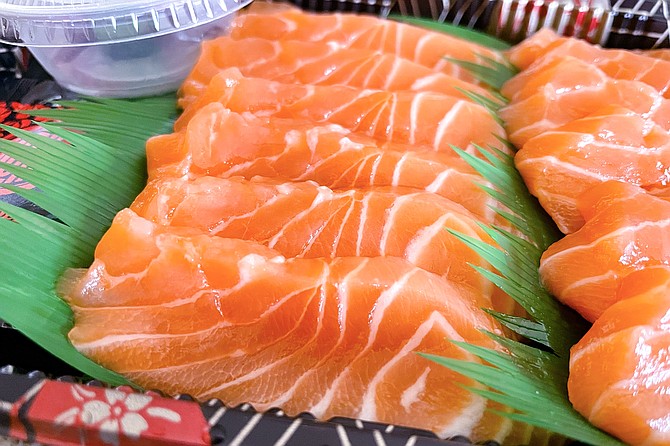 A grab-and-go tray of salmon sashimi for a good value — roughly a dollar per piece