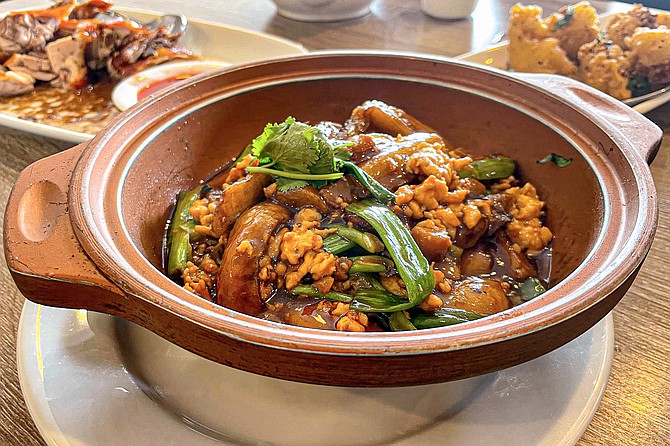A clay pot casserole featuring eggplant, minced chicken, and the occasional pungent bite of salted fish