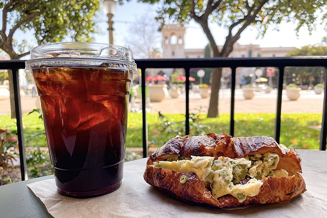 Cold brew and an egg croissant featuring asparagus and green beans