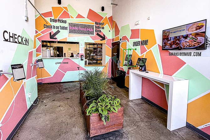 The Barrio Food Hub service counter: delivery drivers to the left; self-service ordering kiosks to the right