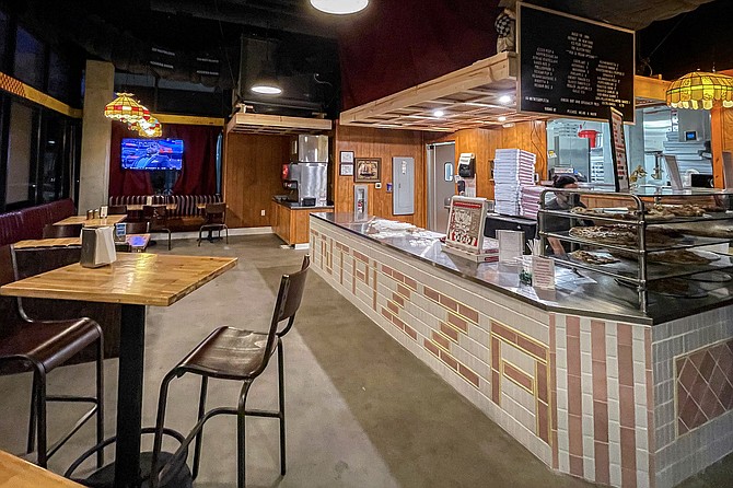 Inside the shop, pizza is available whole pie or by the slice.