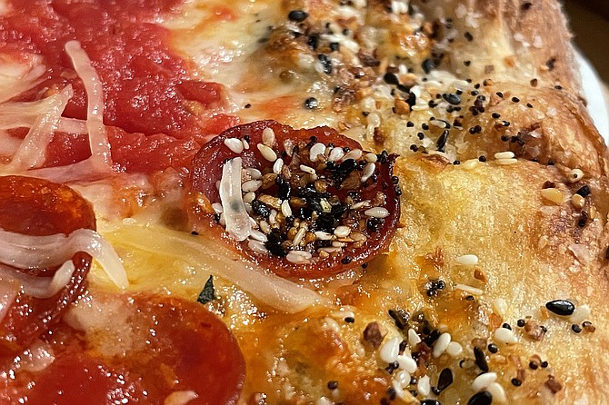 A cupped slice of pepperoni collects everything bagel toppings