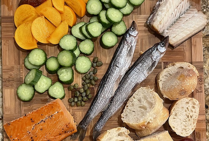 A smoked fish board made at home, featuring smoked black cod, smoked smelt, and hot smoked salmon from Smoked and Tasty