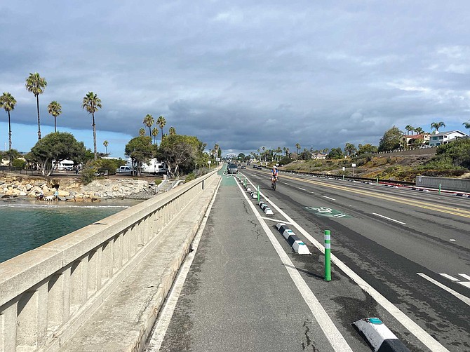Bicyclist using sharrows where bike lane and pedestrian walkway converge on Encinitas Coast Highway.